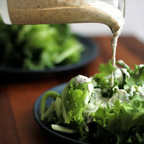 Photo of salad dressing being drizzled onto lettuce