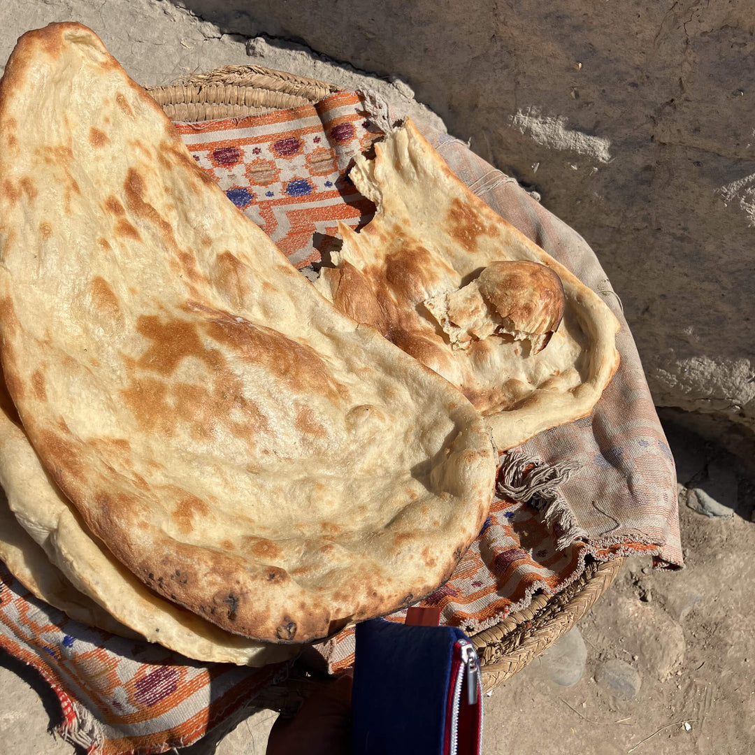 Naan flatbreads on a woven mat with a textured background