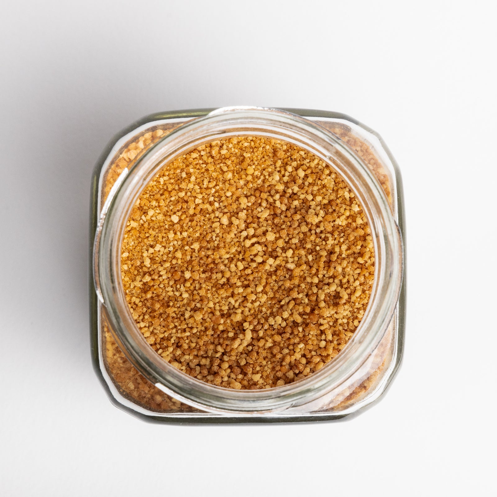 Glass jar filled with brown sugar on a light gray background