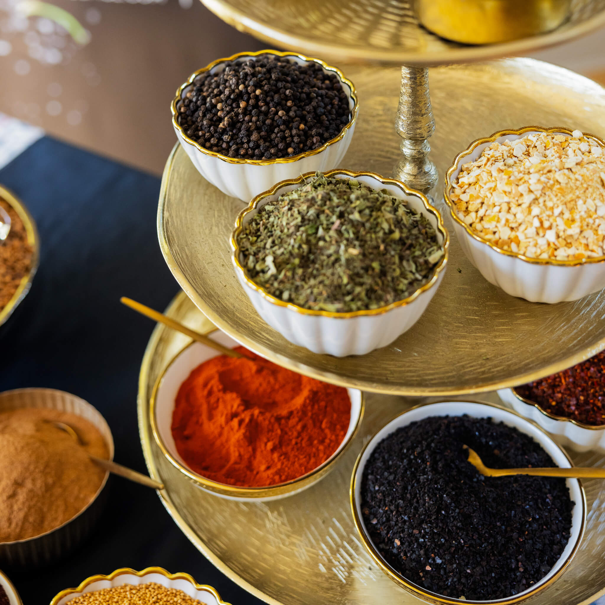 Tiered spice rack with various spices on a dark surface