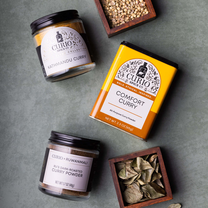 Curio Spices collection with curry powder and spices on a gray surface