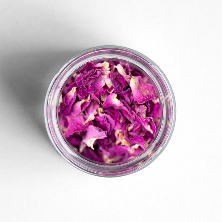 Top down image of a clear jar filled with Curio moroccan rose petals