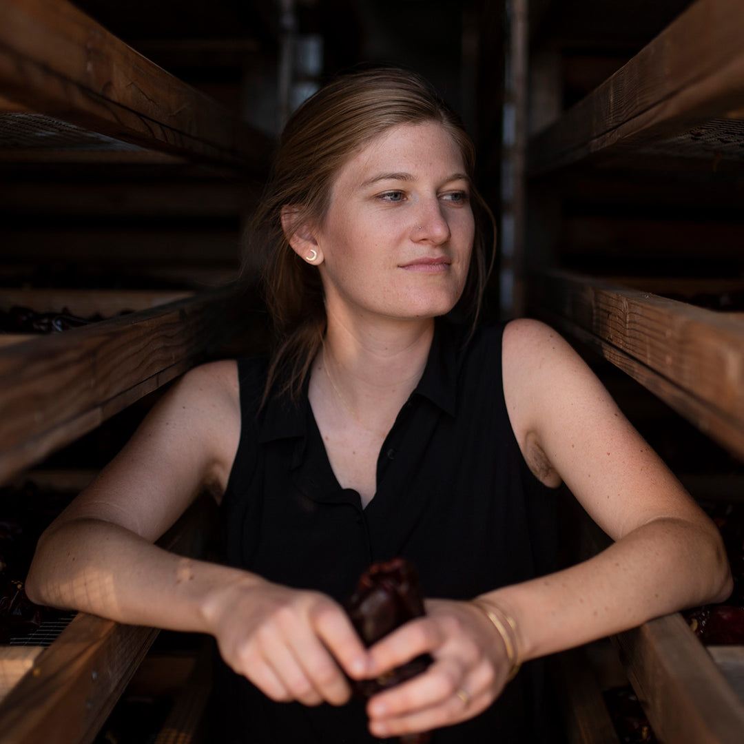 Woman holding a bottle in a wooden setting