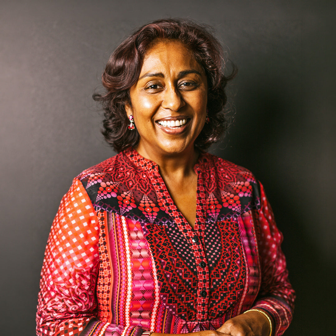 Woman wearing a colorful patterned outfit against a dark background